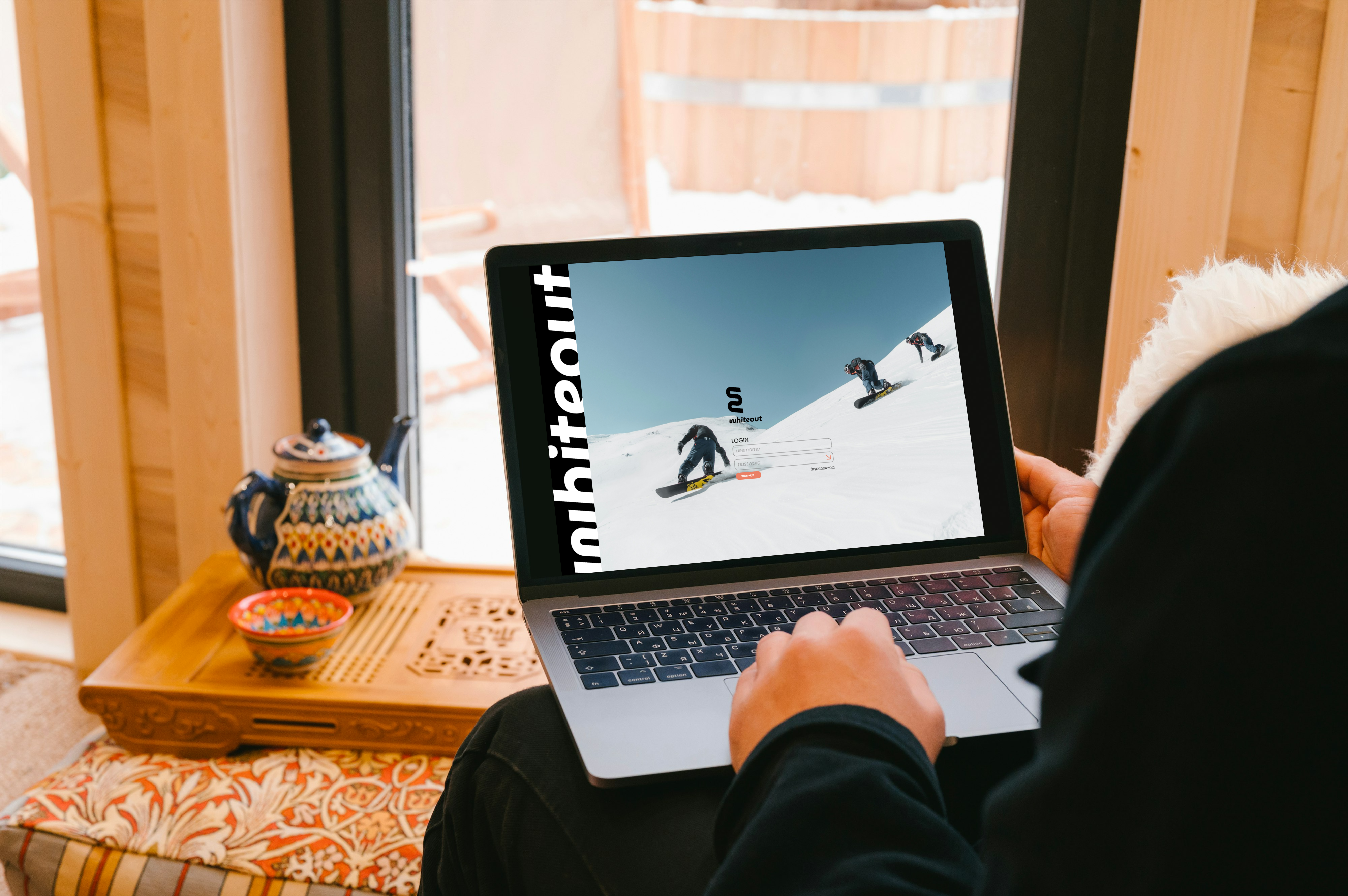 snowboarding website on computer in winter cabin